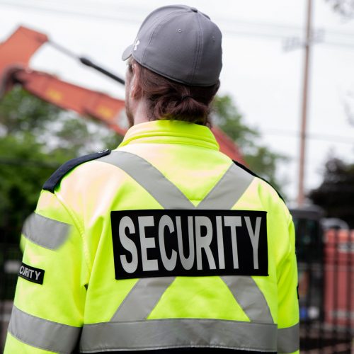 A security guard patrolling the street next to the construction area